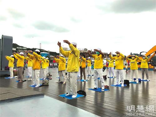 '圖1～2：台灣基隆部份法輪功學員二零二一年十月十七日在海洋廣場煉功弘法講真相。圖為煉法輪功第二套功法。'