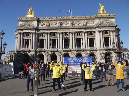'圖6：二月二十八日下午，法輪功學員在巴黎歌劇院廣場進行了講真相和徵簽的活動。圖為法輪功學員演示功法'