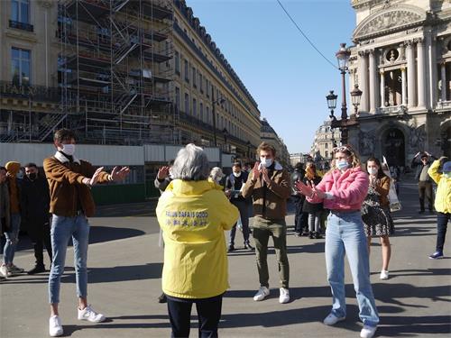 '圖7：幾個年輕人在巴黎歌劇院廣場學煉法輪功'