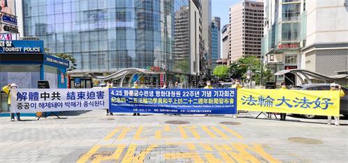 '圖1：韓國法輪功學員分別同步在首爾、釜山、光州和濟州四處，舉辦了紀念四・二五和平上訪記者會。圖為在首爾明洞入口的駐韓中共大使館前舉行記者會的場景。'
