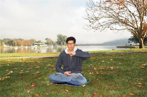 '圖3：堪培拉學員李健榮在公園煉法輪功第五套功法──神通加持法。'