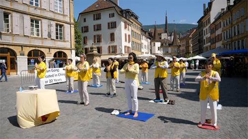 '圖1：二零二一年七月二十日，部份瑞士法語區法輪功學員在納沙泰爾市老城的中心阿勒廣場（Place des Halles），舉行反迫害二十二週年紀念活動。'