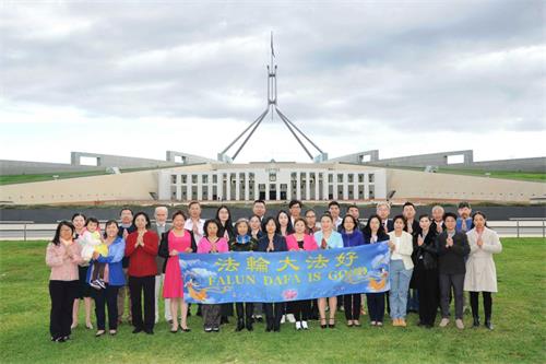 '圖1：在澳洲首都聯邦國會大廈前，堪培拉大法弟子慶祝法輪大法弘傳世界三十週年。恭祝師尊生日快樂！'