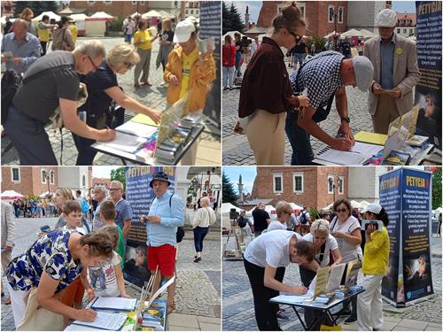 圖1～2：二零二二年七月九日，法輪功學員來到位於波蘭東南部的歷史名城──桑多梅日（Sandomierz），舉辦信息日活動，向當地市民及遊客傳播法輪功的真相，並徵簽。在了解真相後，許多人紛紛在徵簽表上簽名。