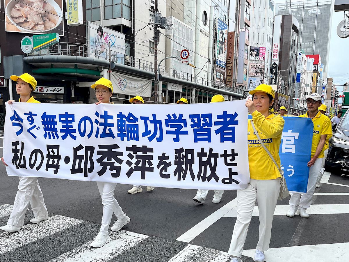 '圖20:法輪功學員張麗玲女士(中)參加關西遊行。(明慧網)'