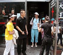 二零零八年六月一日，穿著印有中英文「法輪大法好」和「真善忍」的T恤衫的孫女士（左一）和黃女士（左三）及女兒被法拉盛「十里香菜館」告知「不服務法輪功」並逐出門外
