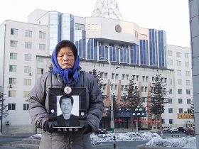 李龍吉七十二歲的母親手捧老伴的遺照