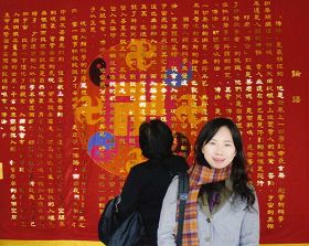 佩蓉參加台灣學員修煉心得交流會，在巨幅《論語》前留影