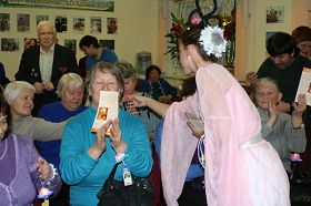 欣賞了法輪功學表演的蓮花舞，老人們高興地接過法輪大法簡介和精美的紙蓮花