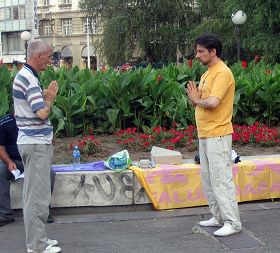 塞爾維亞法輪功學員在首都貝爾格萊德市中心舉辦活動。德揚（左二）教路人煉法輪功