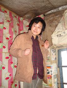 被迫害致瘋的柳志梅，當有人試圖接近，她就攥著雙手躲向自家牆角（攝於二零一零年冬）