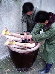 酷刑演示：手腳用膠帶纏起來放入盛滿水的大水缸裏