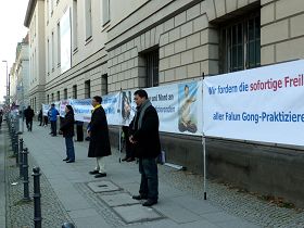 法輪功學員在德國電信大樓對面展開橫幅抗議迫害元凶賈慶林。