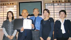 台灣會館理事長蔡明峰先生（中）頒發褒獎給楊斌德先生（左二）。