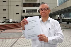 香港神韻晚會主辦方發言人於二零一一年三月九日在高等法院外展示裁定主辦方勝訴的判決書。