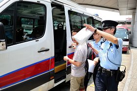 涉嫌在紅磡火車站指使大陸小學生進行破壞的一名男子被警方拘留，帶上警車。