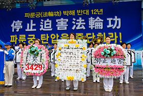 '二零一一年七月十六日，韓國八大市民團體與法輪功學員冒雨在首爾廣場舉行聯合集會，譴責中共對法輪功長達十二年的人權迫害。圖為現場展示被中共迫害致死的中國法輪功學員。'