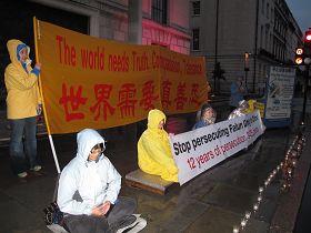 法輪功學員冒雨在中共英國倫敦大使館前舉行反迫害燭光守夜活動
