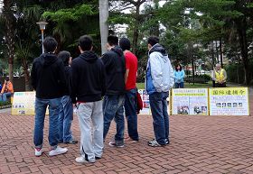 來自香港的年輕人聽法輪功學員解說迫害真相