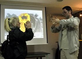 '在「法輪功反迫害」圖片展現場，參觀者在學習法輪功功法。'