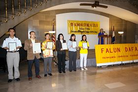 法輪功學員們展示各城市給法輪大法的褒獎證書