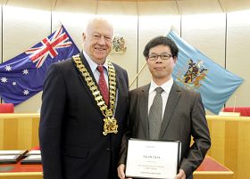 市長（左）在市政府議員會議上為法輪功團體代表頒獎