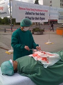 在國際器官移植會議開會地點前，法輪功學員模擬演示中共活摘器官。