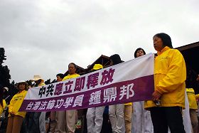 法輪功學員在阿里山火車站前拉橫幅要求釋放被中共非法扣押的學員鍾鼎邦