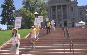 法輪功學員手舉真相板從州政府階梯廣場出發開始反迫害步行活動。