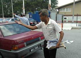 '馬來西亞法輪功學員前往新紀元學院遞交公開信，遭到四個華教界人士的野蠻對待。圖為其中一人搶走和撕毀資料後，還不斷對著法輪功學員謾罵。'