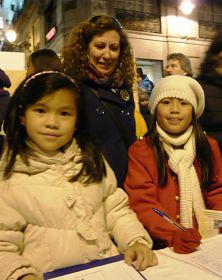 一位女士與自己領養的兩個中國女孩一同簽名支持法輪功