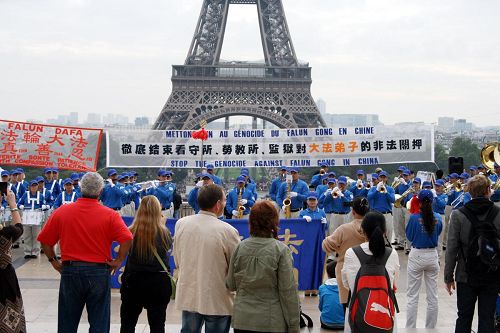 '歐洲部份法輪功學員在巴黎鐵塔前集會，展現法輪功的美好，並揭露中共活摘器官等種種罪行。'