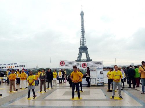 '歐洲部份法輪功在巴黎鐵塔前演示功法，傳播法輪功的真相。'