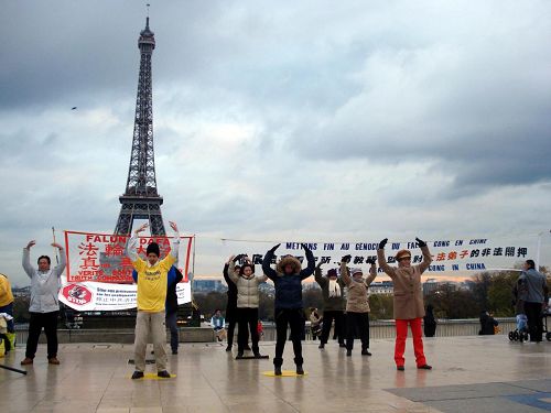 '法國部份法輪功學員來到埃菲爾鐵塔旁的巴黎人權廣場，進行了煉功、講真相'