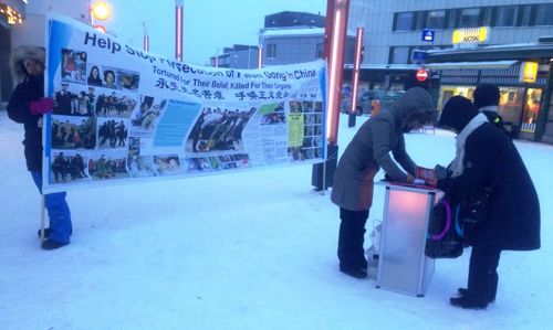 圖1-3：法輪功學員在地處北極圈的芬蘭羅瓦涅米市徵簽，譴責中共迫害