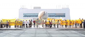 法輪功學員在機場外抗議陳德銘，要求中共停止迫害法輪功