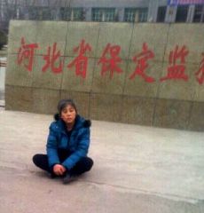 悲憤的鄭祥星妻子孫素雲坐在保定監獄外冰冷水泥地上，向社會呼救