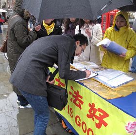 '在倫敦聖馬丁廣場，英國民眾在雨中仍踴躍地在給國會議員的請願信上簽名'