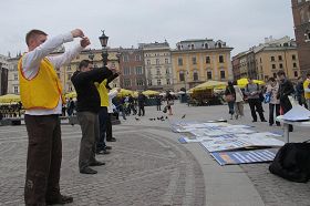 '法輪功學員在克拉科夫市古城中心廣場向民眾展示法輪功功法'