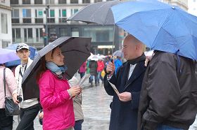 '風雨中人們駐足了解真相，簽名反迫害'