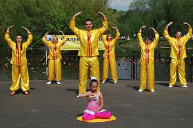 法輪功學員們身穿金黃色的服裝展示了五套功法