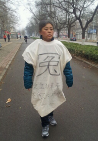 2013年3月鄭祥星妻子為救鄭祥星被迫穿冤衣上保定街頭喊冤。