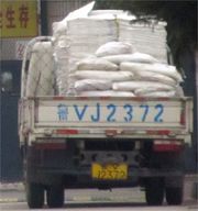 運輸原材料的卡車，車號是「魯VJ2372」，車上拉著成摞的疊好的空袋子和盛滿原材料的像化肥袋的白袋子。卡車把原材料拉進昌樂勞教所監區，供被關押者（包括法輪功學員）加工成產品，銷往全國各地甚至國外。