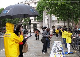 圖1、2：二零一三年六月十五日倫敦聖馬丁廣場：英國法輪功學員在雨中堅持進行講真相，徵簽反迫害活動。