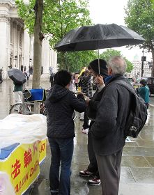 圖4：法輪功學員繼續冒雨徵集支持反迫害簽名。