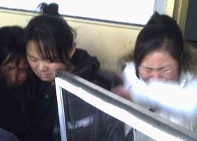 圖：二零一一年二月，在佳木斯監獄，秦家妻女見到秦月明遺體痛苦萬分。