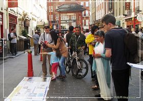圖2：英國法輪功學員在倫敦唐人街演示功法、講真相並徵集支持反迫害的簽名，路人紛紛駐足了解真相。