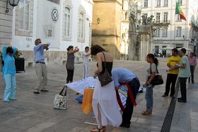 Coimbra的民眾看真相展板和演示功法，簽名支持反迫害