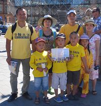 '圖3：來自捷克的兩位越南裔法輪功學員帶著家人和孩子參加了「七二零」法輪功哥本哈根大遊行，並在市政廳廣場上發放法輪功真相傳單'