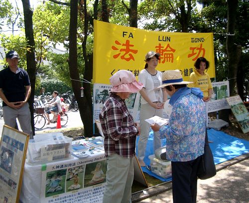 圖2：學員們在第十八屆稻澤夏季活動節展位上向市民介紹法輪功